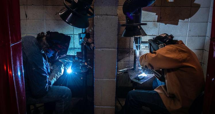 Two students welding projects in classroom lab